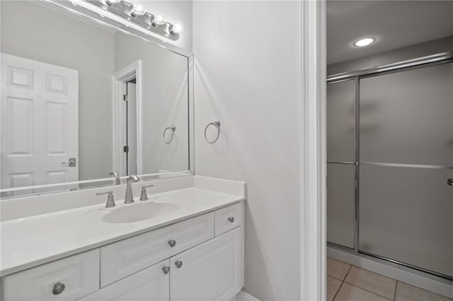 bathroom featuring tile patterned flooring, a stall shower, and vanity