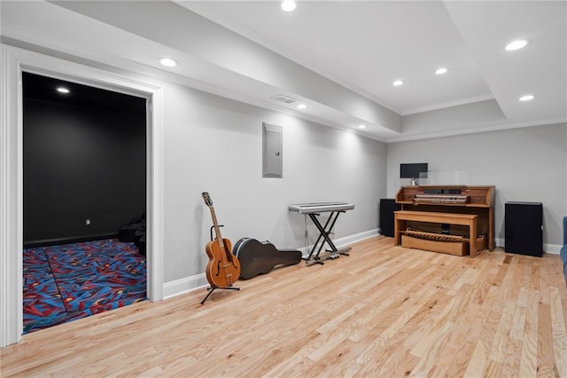 interior space with electric panel, wood finished floors, recessed lighting, and crown molding