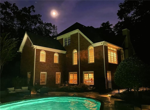 rear view of house featuring an outdoor pool