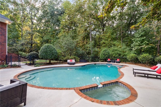 view of pool featuring a patio, a pool with connected hot tub, and fence