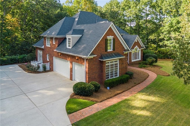 view of front facade featuring driveway, a front lawn, roof with shingles, a garage, and brick siding