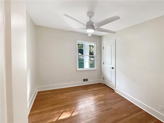 empty room with ceiling fan and hardwood / wood-style floors