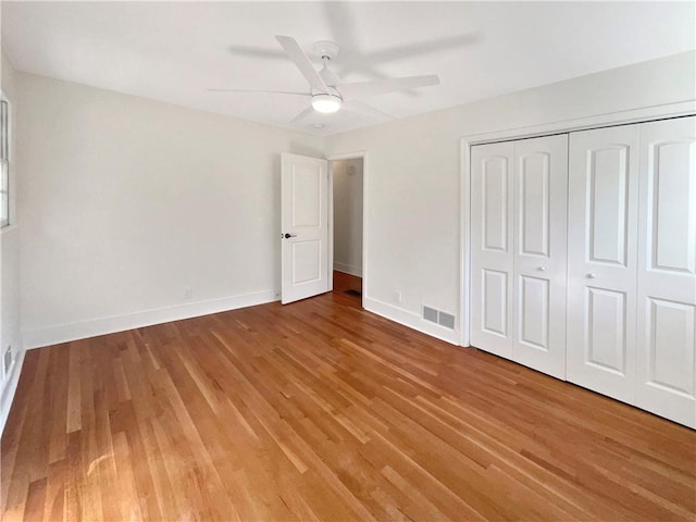 unfurnished bedroom featuring a closet, light wood-type flooring, and ceiling fan