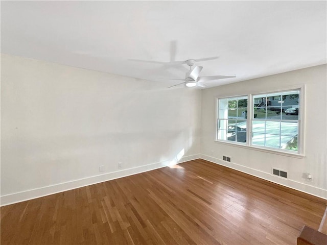 empty room with hardwood / wood-style floors and ceiling fan