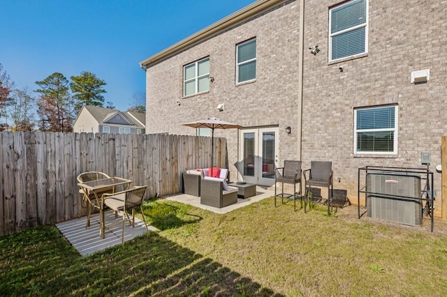 back of property with an outdoor hangout area, a patio, central AC unit, and a lawn