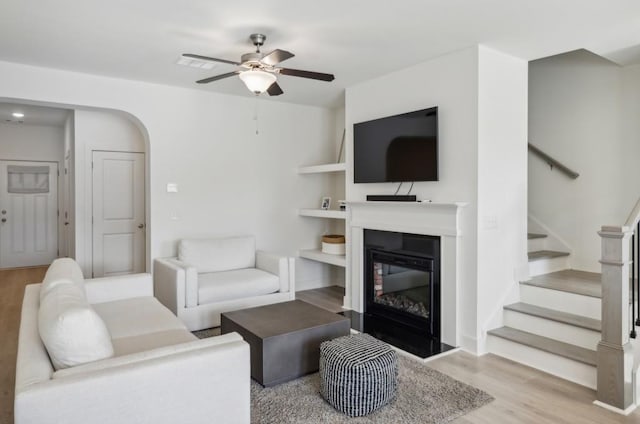 living room with ceiling fan and light hardwood / wood-style flooring