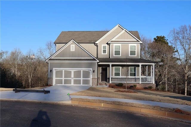 599 Calgary Downs Dr, Winder, GA 30680 - craftsman house featuring covered porch, concrete driveway, board and batten siding, roof with shingles, and a garage