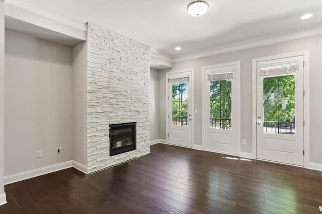 unfurnished living room with hardwood / wood-style flooring, recessed lighting, a fireplace, baseboards, and ornamental molding