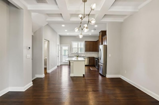 kitchen featuring a center island, dark wood-style flooring, stainless steel appliances, light countertops, and baseboards