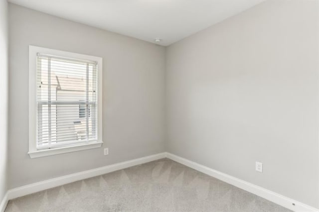 unfurnished room featuring carpet and baseboards