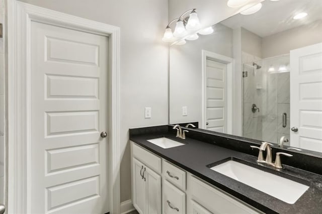 full bath with double vanity, a stall shower, and a sink