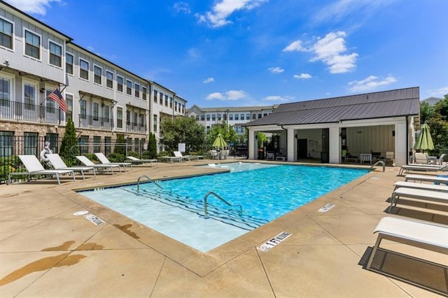 community pool with fence and a patio