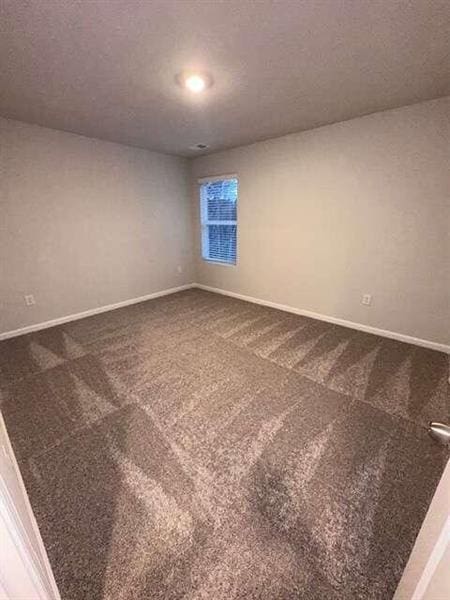 carpeted empty room with baseboards and a textured ceiling