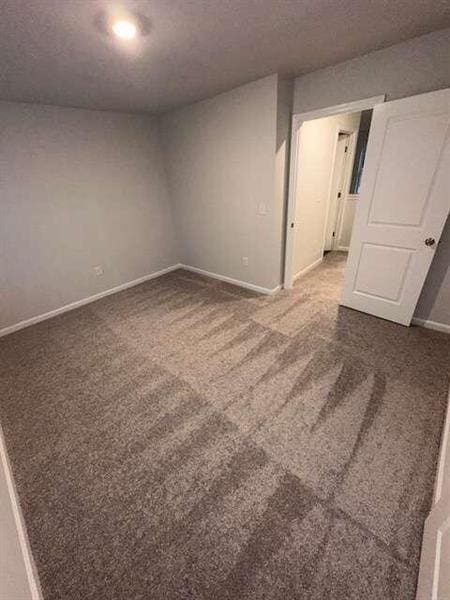 carpeted empty room with baseboards