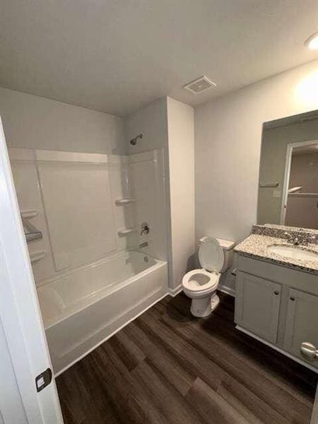 full bathroom featuring vanity, wood finished floors, visible vents, bathing tub / shower combination, and toilet