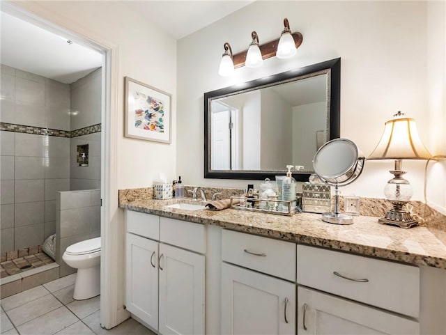 bathroom with tile patterned floors, vanity, toilet, and tiled shower