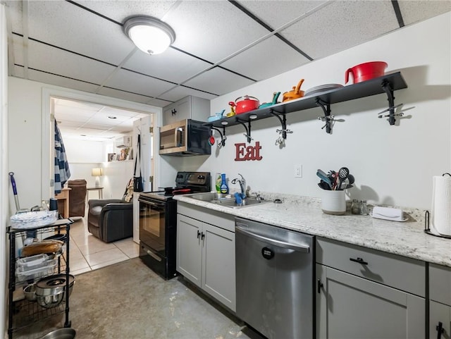 kitchen with appliances with stainless steel finishes, gray cabinets, a drop ceiling, and sink