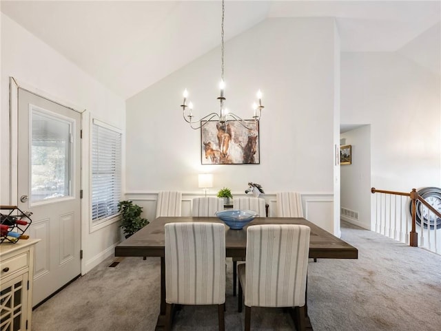 carpeted dining space featuring lofted ceiling and an inviting chandelier