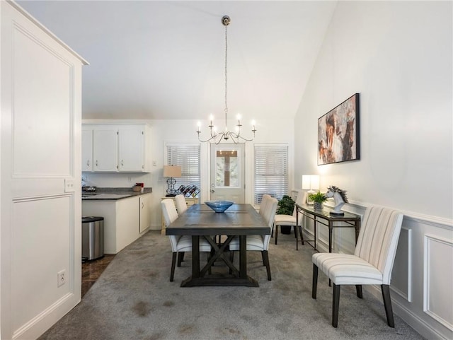 dining area with carpet flooring, a chandelier, and vaulted ceiling