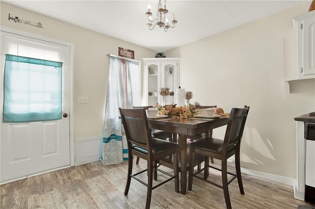 dining area with an inviting chandelier and light wood-type flooring