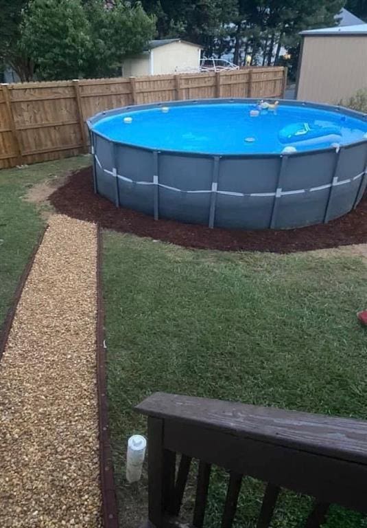 view of pool featuring a lawn