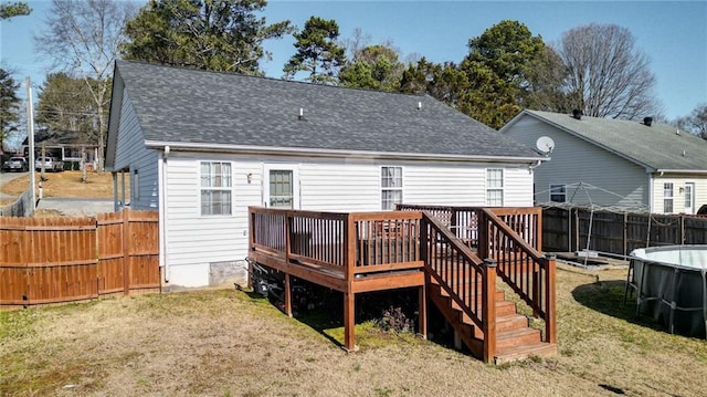 rear view of property featuring a swimming pool side deck and a yard