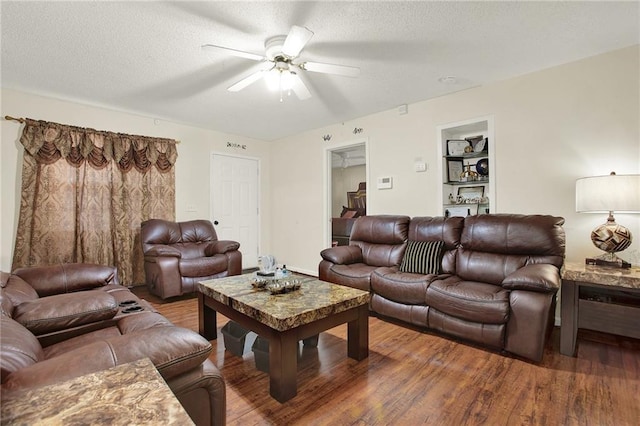 living room with ceiling fan, hardwood / wood-style floors, and a textured ceiling