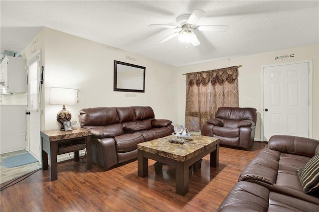 living room with a textured ceiling, wood-type flooring, and ceiling fan