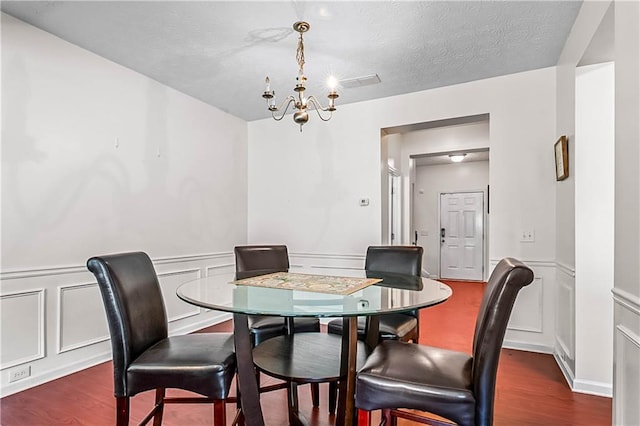 2555 Flat Shoals Rd Unit 2006, Atlanta, GA 30349 - dining room with a chandelier, a decorative wall, dark wood finished floors, and a wainscoted wall