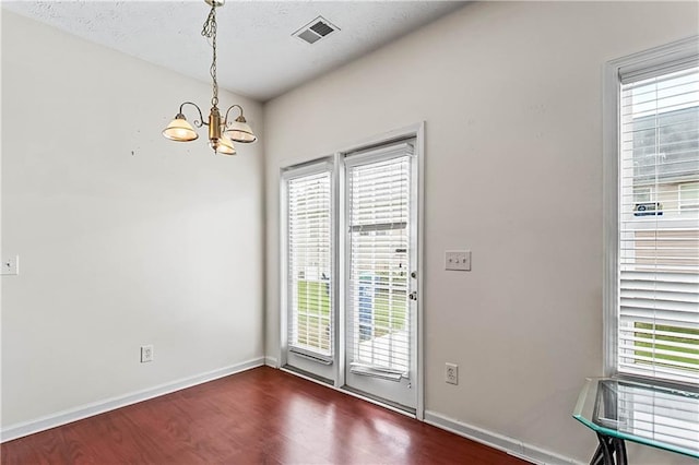 2555 Flat Shoals Rd Unit 2006, Atlanta, GA 30349 - unfurnished dining area featuring a chandelier, dark wood finished floors, and plenty of natural light