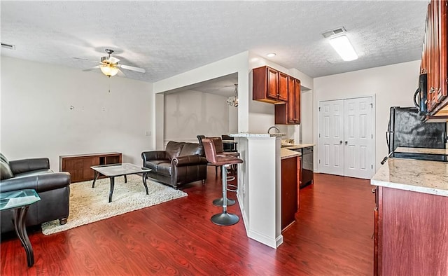 2555 Flat Shoals Rd Unit 2006, Atlanta, GA 30349 - living room featuring dark wood finished floors, ceiling fan, and a textured ceiling