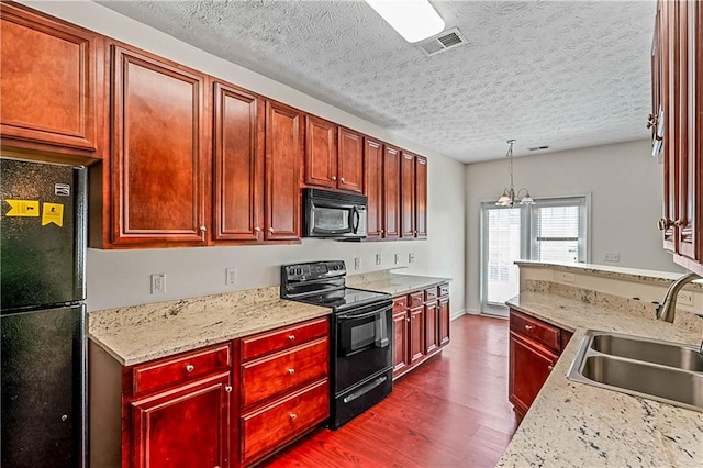 2555 Flat Shoals Rd Unit 2006, Atlanta, GA 30349 - kitchen featuring black appliances, dark wood-style floors, dark brown cabinets, a chandelier, and decorative light fixtures
