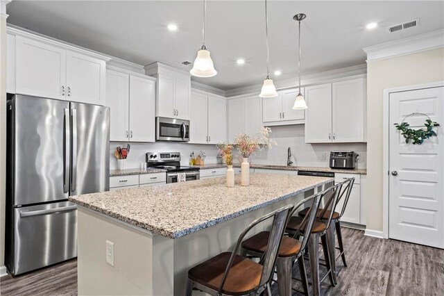 359 Crider Ct, Woodstock, GA 30188 - kitchen featuring stainless steel appliances, a kitchen island, dark wood-style floors, a breakfast bar area, and recessed lighting