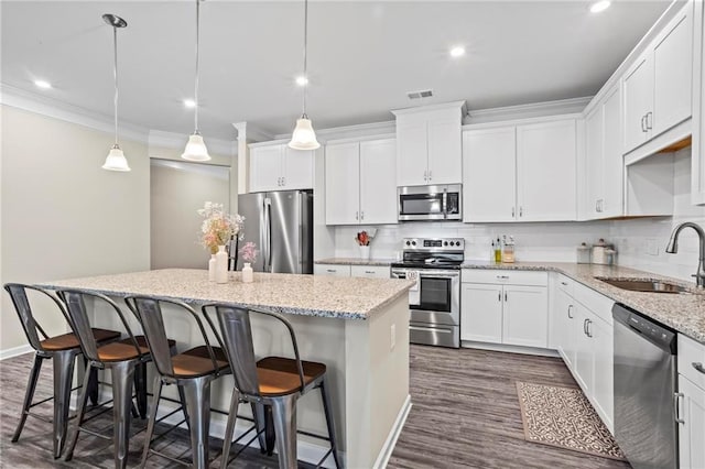 359 Crider Ct, Woodstock, GA 30188 - kitchen featuring stainless steel appliances, a sink, a kitchen island, dark wood finished floors, and crown molding