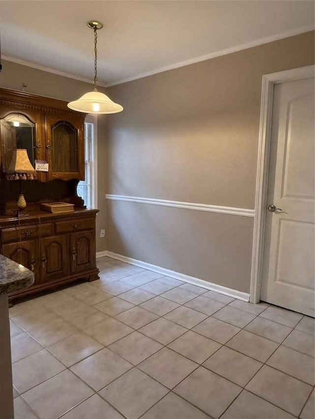 unfurnished dining area featuring light tile patterned floors and ornamental molding