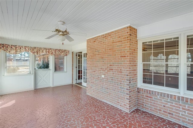 unfurnished sunroom featuring ceiling fan