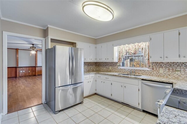 kitchen featuring ornamental molding, appliances with stainless steel finishes, sink, and white cabinets