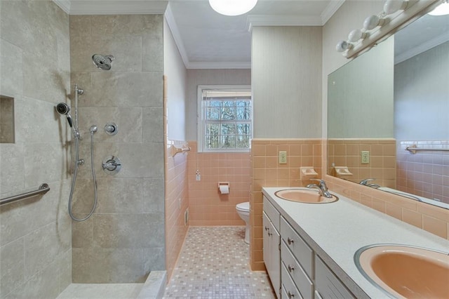 bathroom featuring tiled shower, toilet, tile walls, ornamental molding, and vanity