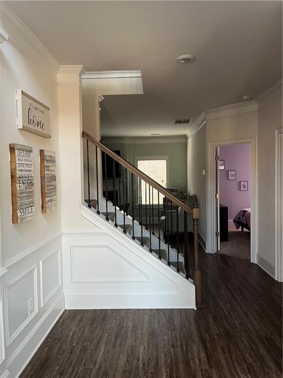 staircase featuring wood-type flooring and crown molding