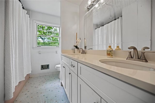 3332 Saint John Dr, East Point, GA 30344 - bathroom featuring toilet, double vanity, and baseboards