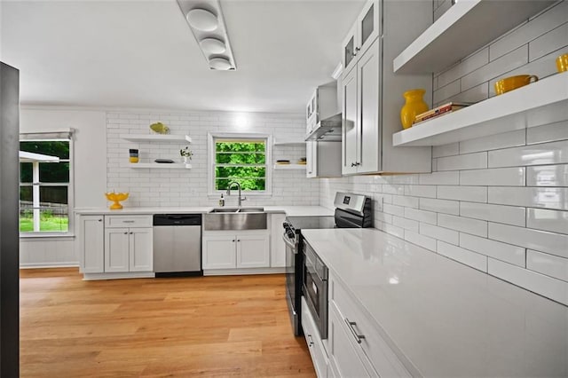 3332 Saint John Dr, East Point, GA 30344 - kitchen with open shelves, stainless steel appliances, a sink, light wood-style flooring, and decorative backsplash