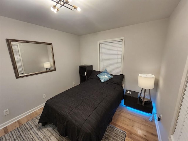 bedroom with baseboards and wood finished floors