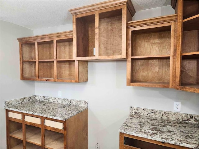 kitchen with light stone countertops and a textured ceiling