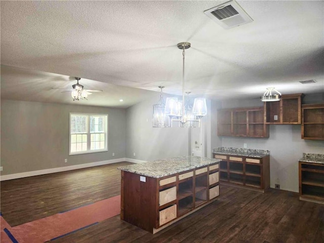 kitchen with a center island, hanging light fixtures, a textured ceiling, dark hardwood / wood-style floors, and ceiling fan with notable chandelier