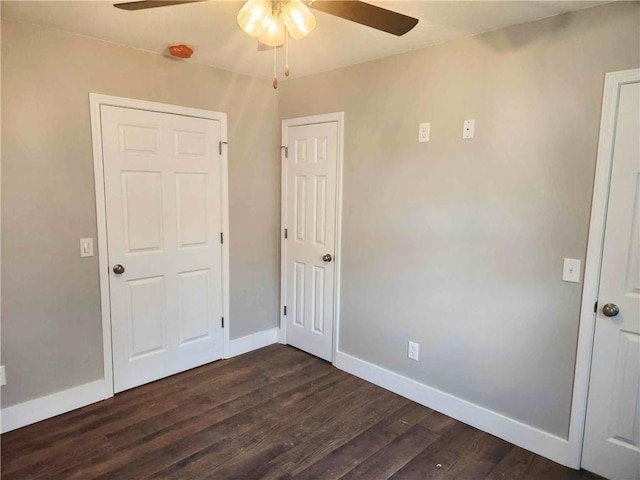 unfurnished bedroom with ceiling fan and dark hardwood / wood-style floors