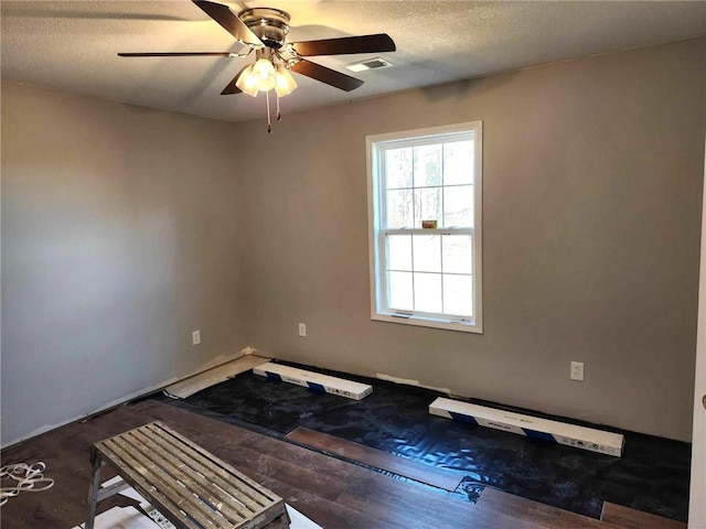 unfurnished room with ceiling fan and a textured ceiling