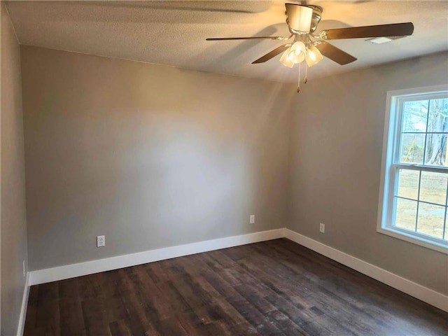 unfurnished room with dark wood-type flooring, ceiling fan, plenty of natural light, and a textured ceiling