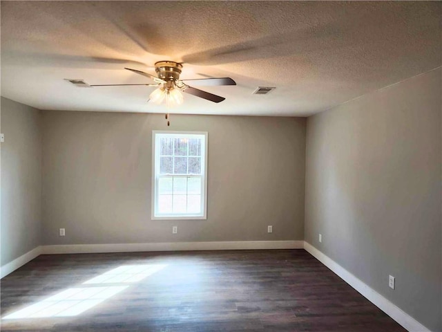 spare room with dark wood-type flooring, a textured ceiling, and ceiling fan