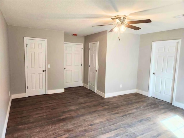 unfurnished bedroom featuring ceiling fan and dark hardwood / wood-style flooring