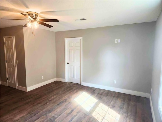 empty room featuring dark wood-type flooring and ceiling fan